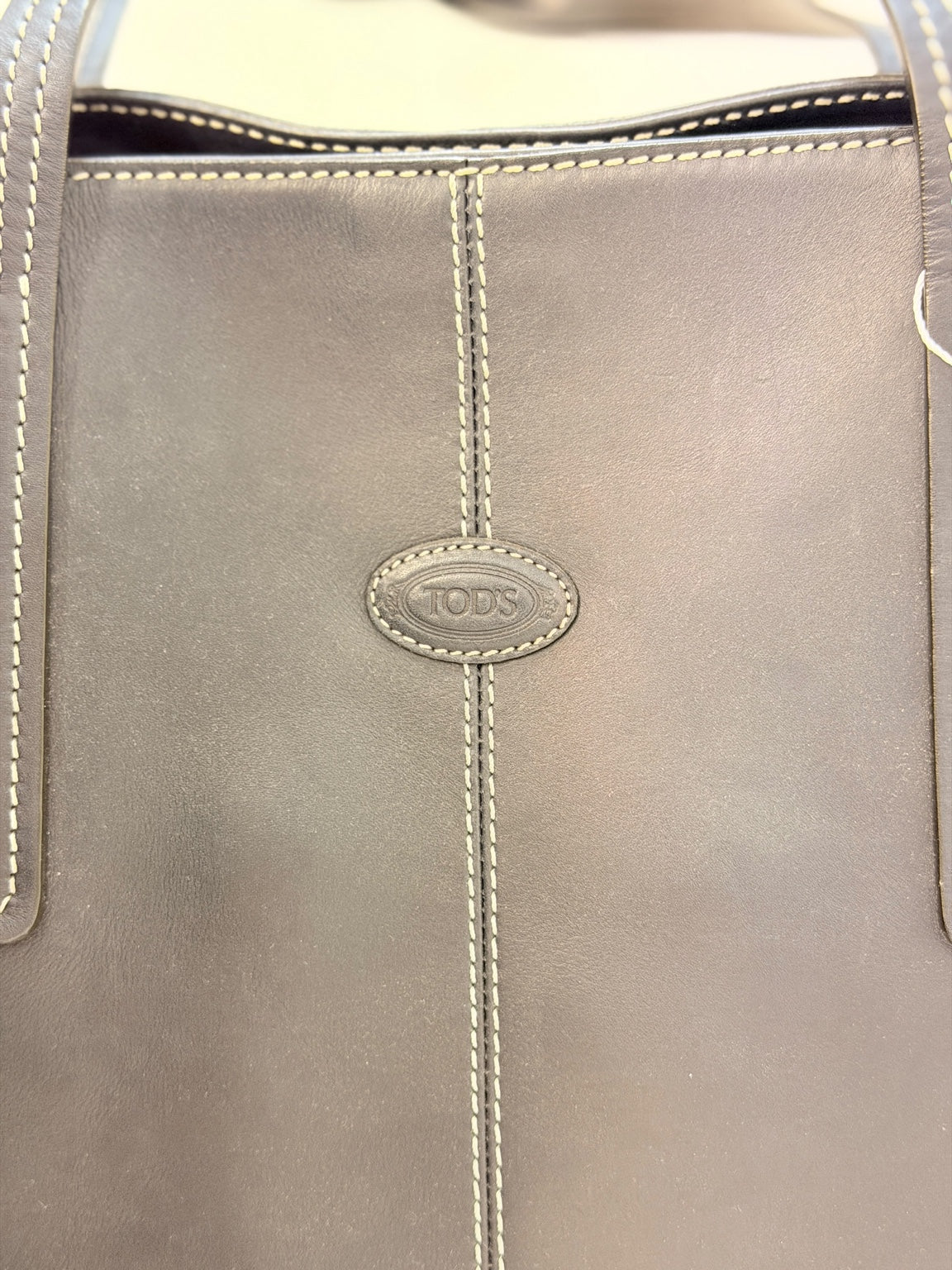 Tod’s embossed leather logo and contrast stitching detail